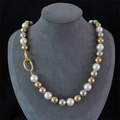 Elegant multi-color pearl necklace with oval golden clasp on grey jewelry bust display - Necklace