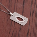 Détail du collier à pendentif rectangulaire en acier inoxydable argenté sur bois sombre - Lettre O