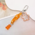 Detailed view of orange acrylic chain and transparent glitter gummy bear pendant charm - Orange