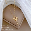Détail du collier clé en titane doré avec pendentif couronne de cœur sur boîte cadeau - Clé Couronne (Or) / Doré