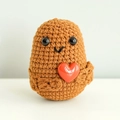 Handmade brown knitted potato doll holding a red heart accessory on white surface - Heart Potato