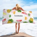 Detail of microfibre beach towel featuring watercolor fruit prints and summer text - Fruit Medley