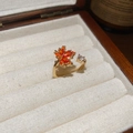 Makro-Detail des 18k vergoldeten Ahornblatt-Rings mit orangen Zirkonias auf einer Box - Roter Zirkonia Ahornblatt Stil / Gold