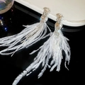 Macro shot of sparkling teardrop earrings featuring white feather fringe and crystal tassels - Silver & White (Silver Earring Post)