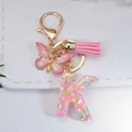 Macro detail of a resin letter K keychain with pink butterfly, tassel and glitters - Letter K