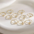 Adjustable gold letter rings with cubic zirconia stones displayed on a white ceramic plate - Letter A / Gold