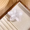 Close-up of translucent white plumeria hair claw clip with pearlescent marble texture - White Leopard