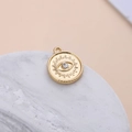 Macro shot of gold plated evil eye charm with clear crystal on white marble surface - Evil Eye Round Disc Style (4#)