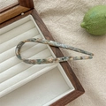 Detalle de horquilla en forma de U de acetato con textura de mármol en joyero de madera - Pintura al óleo azul claro