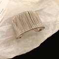 Primer plano de un brazalete de plata ancho trenzado con hilo metálico sobre papel artístico - 4# Estilo Lineal Envuelto - Plata