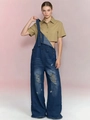 Detail shot of vintage distressed dark blue denim overalls with casual ripped knee design - Blue Black