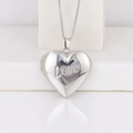 Polished silver heart locket necklace with Love engraving and dainty chain on white - LOVE Heart/Steel