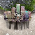 Macro shot of purple crystal hair comb with a silver sun pendant on natural mossy stone - Amethyst Black Wire Silver Sun
