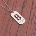 Macro shot of a silver titanium steel lucky tag pendant with intricate hollow pattern - Number 8