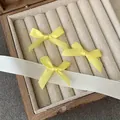 Tres pinzas para el pelo con lazos de satén amarillo en un joyero de madera vintage - Amarillo Leche