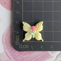 Macro view of 2.5cm resin butterfly accessory with pink rose on a measuring ruler - Yellow Butterfly + Red Rose