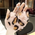 Pink leopard print heart plush keychain with silver metal clasp held in hand - Pink Heart Leopard Pom Pom