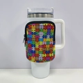 Close-up of a white 40oz tumbler with a colorful puzzle pattern neoprene pouch sleeve - No. 9 Jigsaw Puzzle