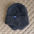 Détails de la maille pelucheuse gris foncé et écusson flocon pour cette toque d'hiver - Taille unique / gris foncé