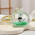 Panda liquid keychain with green sand and golden ring on a white cloud tray - Single Keychain Style / Green