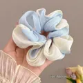 Detail eines blau-beigen Organza-Haargummis mit Faltenstruktur und 12 cm Durchmesser - Blau Farbverlauf Stil