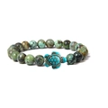 Detailed macro view of a turquoise beaded bracelet featuring a realistic sea turtle charm - African Pine Stone