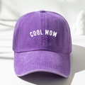 Close-up of a purple washed cotton baseball cap with white COOL MOM print and stitching - Purple