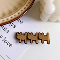 Brown resin hair clip with three cat silhouettes and golden lettering on white card - Brown Dog