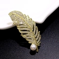 Elegant gold feather brooch with white zircons and a round pearl in a luxury design - Golden Feather Pearl