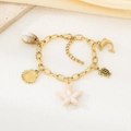 Detailopname van de 18k vergulde zeester- en schelphangers op een maritieme armband - Zeester Dolfijn Zeeschildpad Stijl (KB206904-SXSJ)