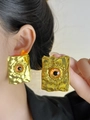 Detail of vintage evil eye square earrings with gold textured metal finish on model - Gold Red Eye Square Earrings