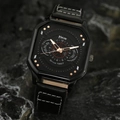 Close-up of a square black quartz watch with rose gold hands on a dark textured rock - HK063 Watch Only / Black