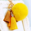 Detail of yellow plush pompom keychain with silk tassels and golden metal ring - Yellow