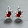 Elegant silver earrings featuring oval red gemstones surrounded by white sparkling zircons - Platinum Plated Red Zirconia