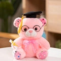Detailed close-up of pink graduation teddy bear with cap, glasses, and diploma - Pink Graduation Bear