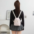 Quilted pink bow pattern mini backpack shown on a model in a minimalist home setting - 19*12*24cm / Pink Grid with Bow