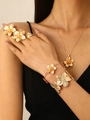 Golden flower jewelry set including necklace, bracelet and three rings on model - Gold 5-Piece Set: Earrings + Necklace + Bracelet + Bangle + Ring