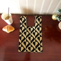 Knitted tote bag with black and gold geometric heart patterns on a dark wooden table - Khaki