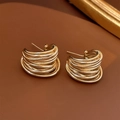 Macro shot of gold layered C-shape metal earrings on a textured brown surface - Golden Wound C-Shape (2#)