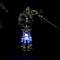 Dettaglio ravvicinato di un fermaglio dorato con lanterna LED blu e perle bianche - F0300 Lanterna di Palazzo - Luce Blu