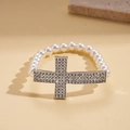 Dettaglio del bracciale con perle barocche e croce di strass scintillanti su base beige - Bracciale-Bianco