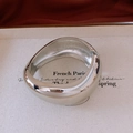 Vista detallada del brazalete ancho de metal pulido con bisagra y diseño minimalista francés - Plateado