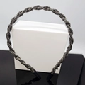 Braided black crystal headband with sparkling beads on a sleek white display pedestal - Grey Rhinestone