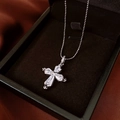Close-up of a silver cross pendant with five sparkling cubic zirconia on a bead chain - Silver