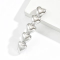Minimalistische silberne Haarspange aus Metall mit fünf Herzen auf weißem Steinblock - 5 Herzen / Silber