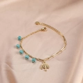 Gold bracelet with blue cube beads and a Tree of Life pendant on champagne silk fabric - Blue Cube Beads / Gold Tree Of Life Blue Beads