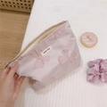 Close-up of pink bow-knot jacquard makeup bag with simple wish label on white fabric - Light Purple