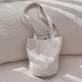 Détail du sac cabas plissé beige montrant la texture du tissu et le fermoir magnétique - Beige