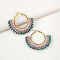 Detail of fan-shaped beaded earrings with purple pearls and green crystals on gold hoops - Purple