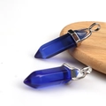 Close-up of dual deep blue crystal hexagonal point pendants with silver metal clasps - Transparent Blue